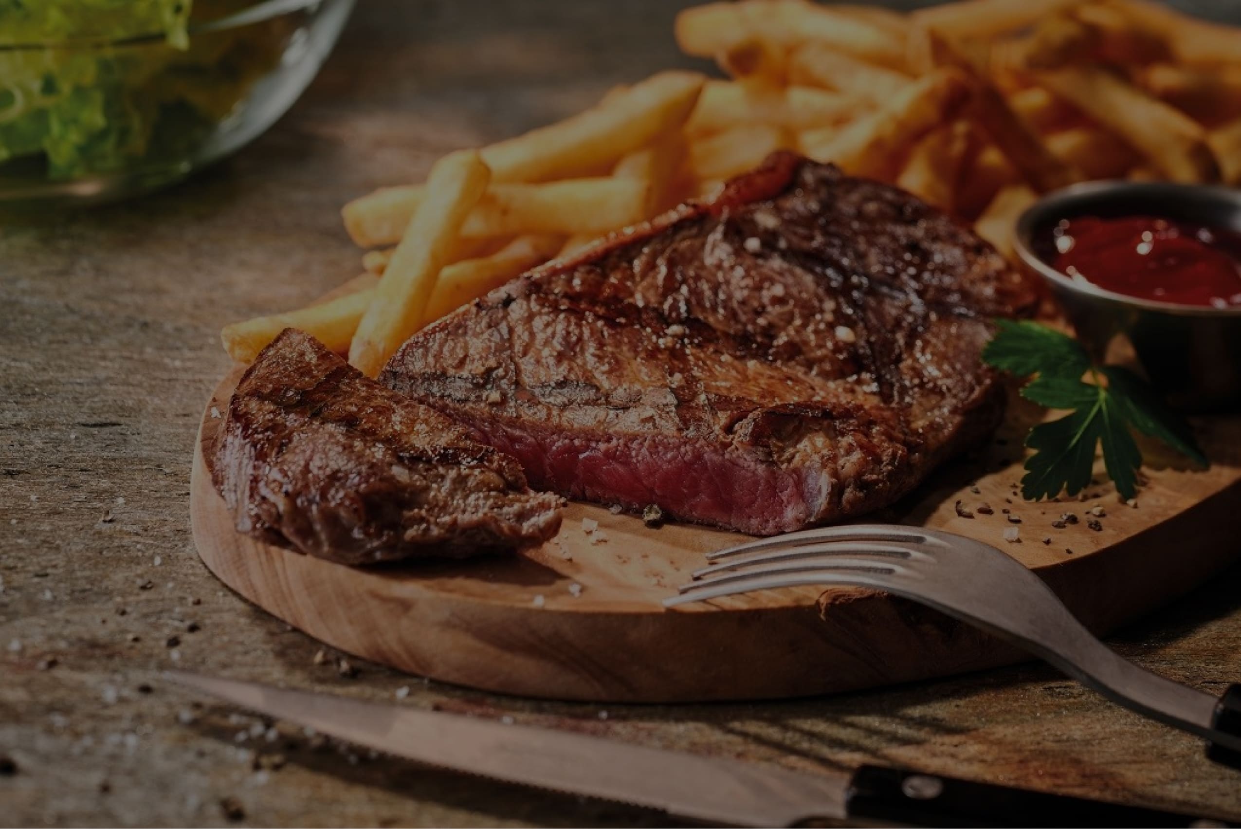 Steak et frites déposés sur une planche en bois