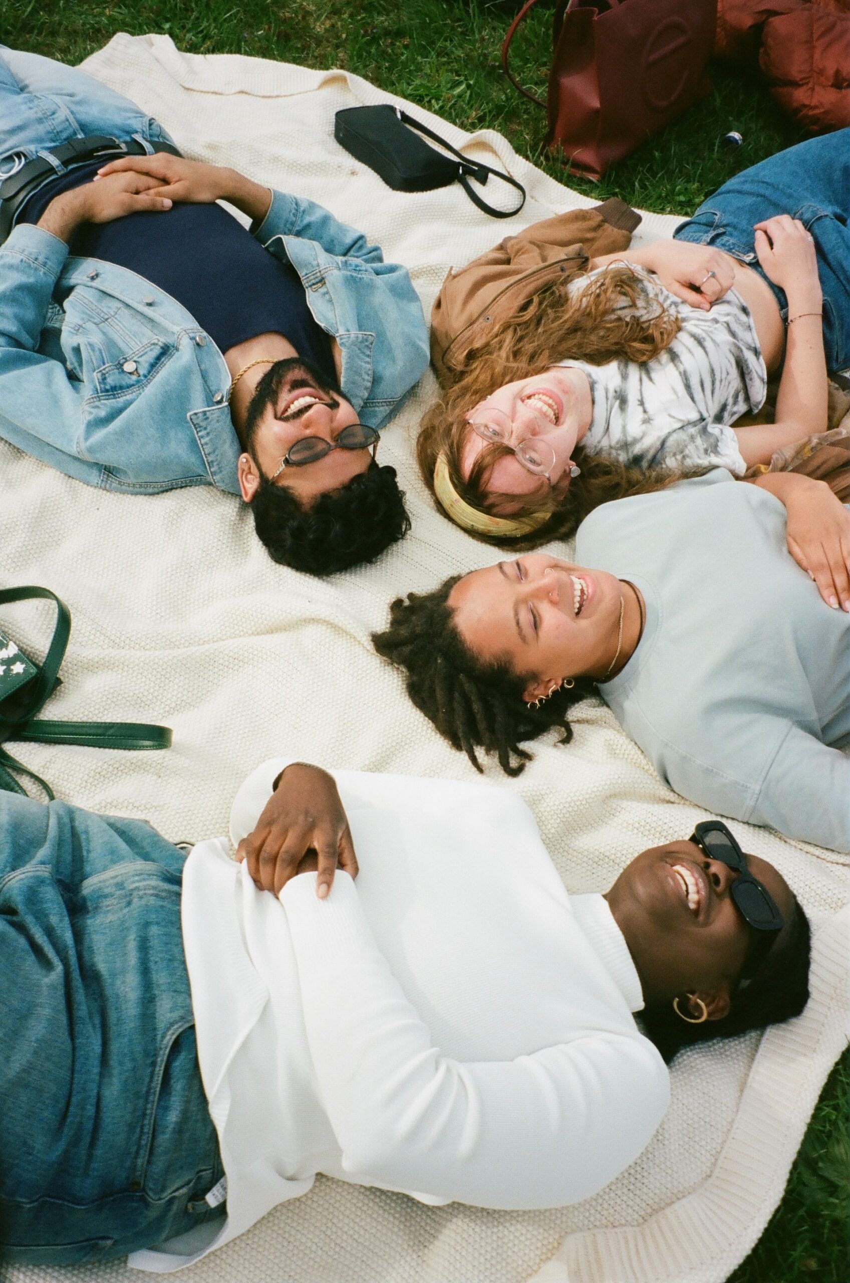 personnes allongées sur un drap dans l'herbe